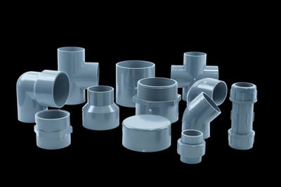 Assortment of grey PVC pipe fittings — tees, elbows, reducers, unions and caps